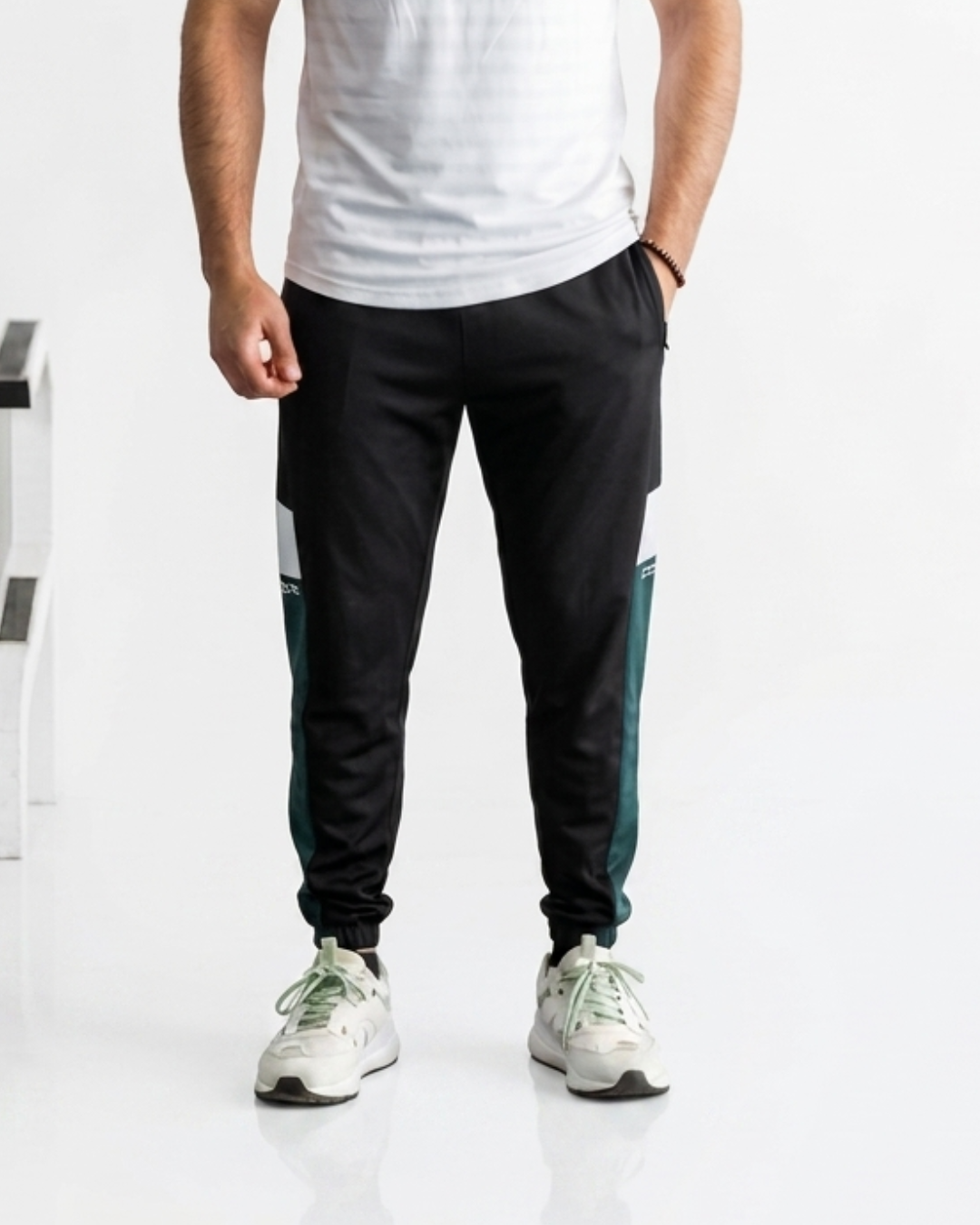Men's casual black joggers with green side stripe detail for sporty style and comfort.